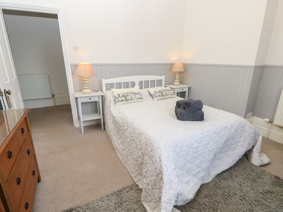 A bedroom with a bed and bedside table at Lancaster House in Sandown