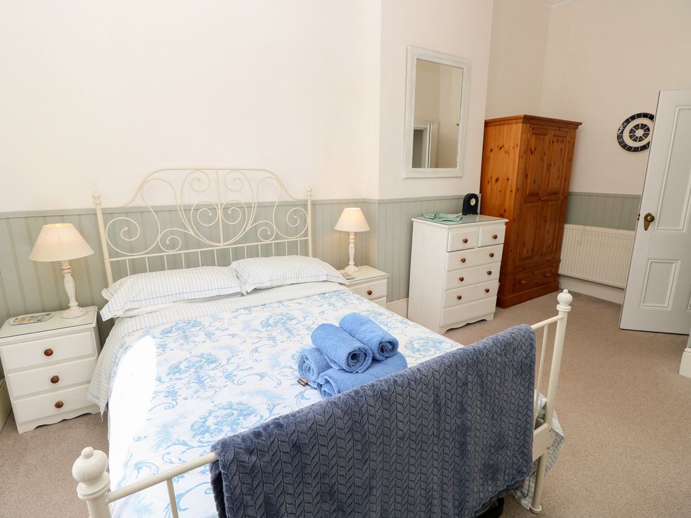 A bedroom with a bed and dresser at Lancaster House in Sandown