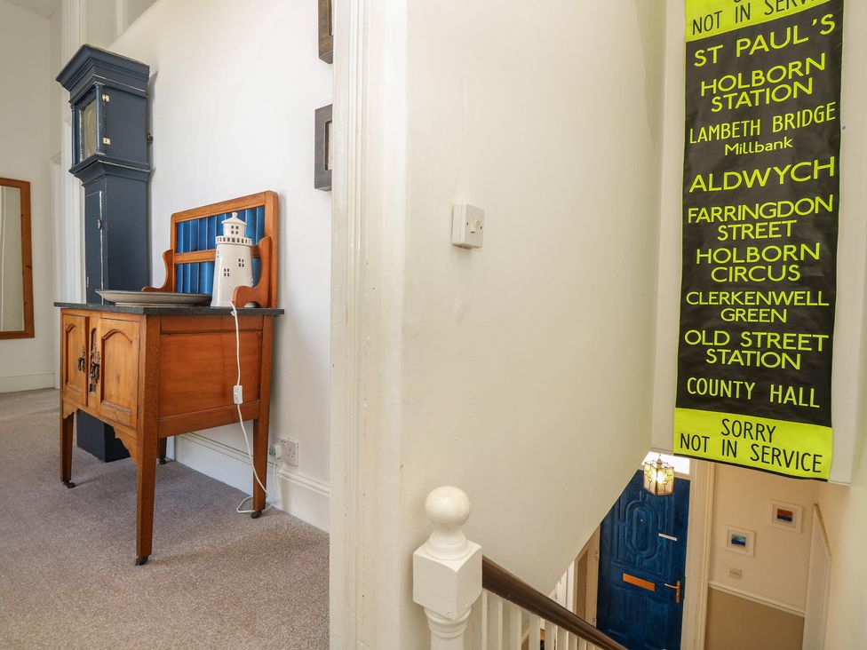 A hallway with a wooden table and a notice board at Lancaster House in Sandown