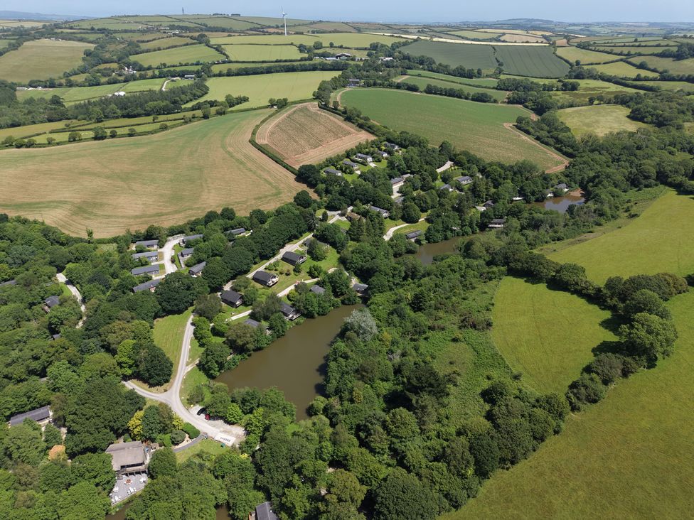 An aerial view of a rural area with houses and ponds at 1 Valley View in Lanreath