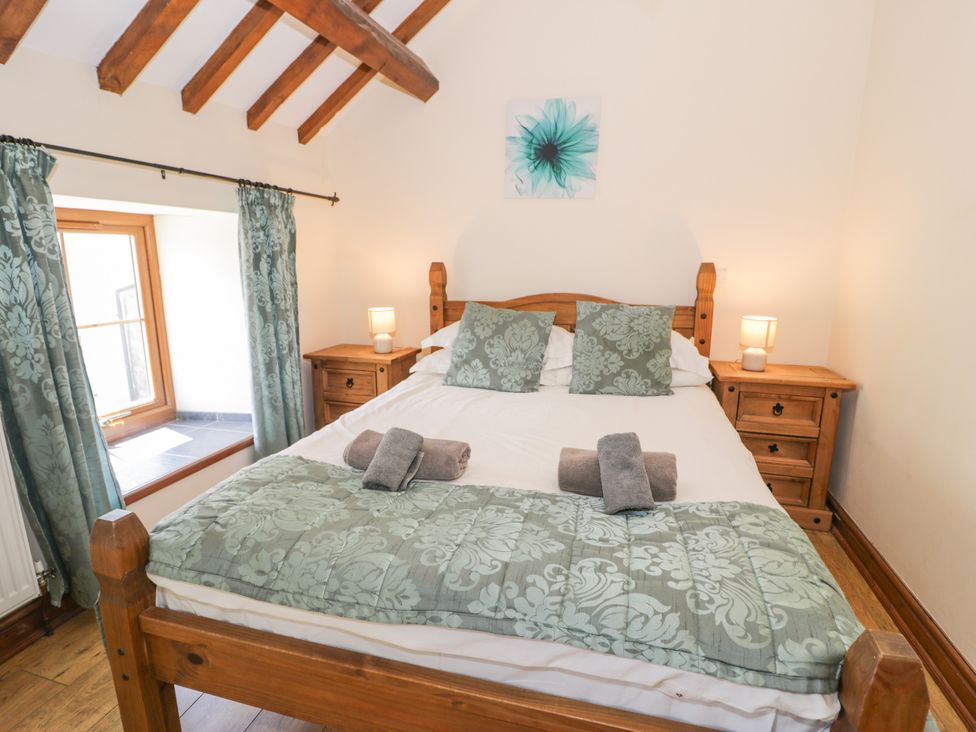 A bedroom with a bed and bedside tables at Stabal-y-Gwedd in Dolwen near Abergele