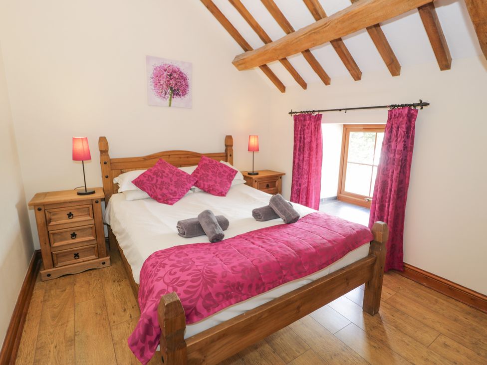 A bedroom with a bed and nightstands at Stabal-y-Gwedd in Dolwen near Abergele