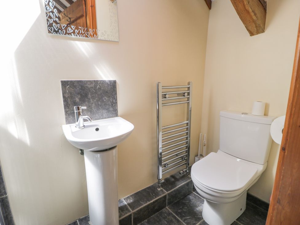 A bathroom with a sink, toilet and towel radiator at Stabal-y-Gwedd in Dolwen near Abergele