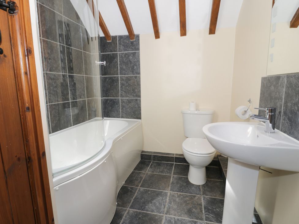 A bathroom with a bathtub, toilet, and sink at Stabal-y-Gwedd, Dolwen near Abergele
