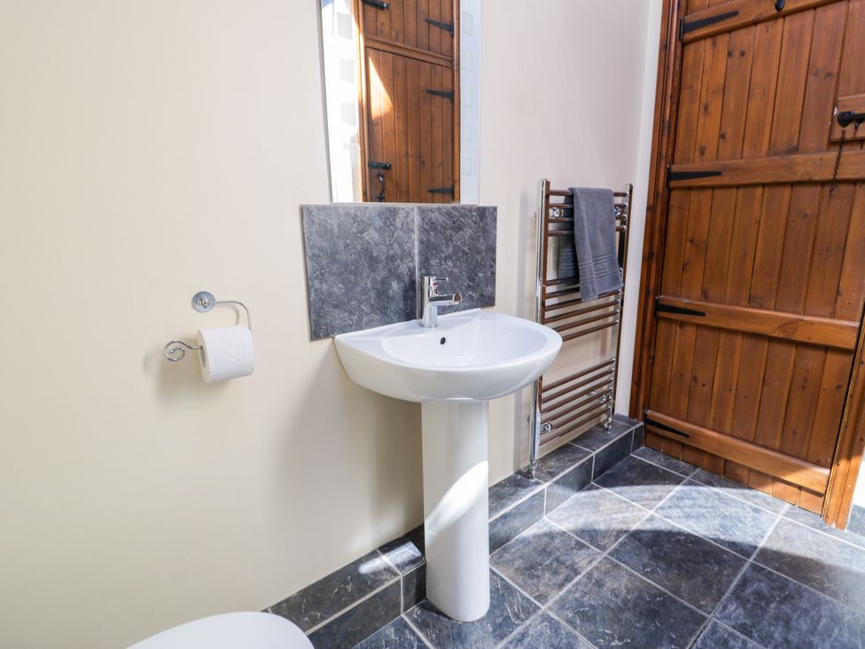 A bathroom with a sink and towel rack at Stabal-y-Gwedd in Dolwen near Abergele