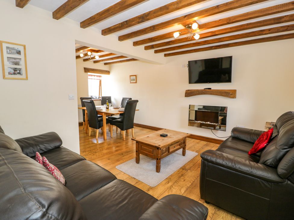 A living room with a sofa and coffee table at Beudy Bach in Dolwen near Abergele