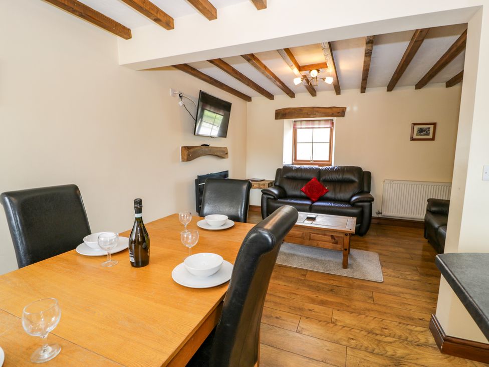 A dining room with a table and chairs at Beudy Bach in Dolwen near Abergele
