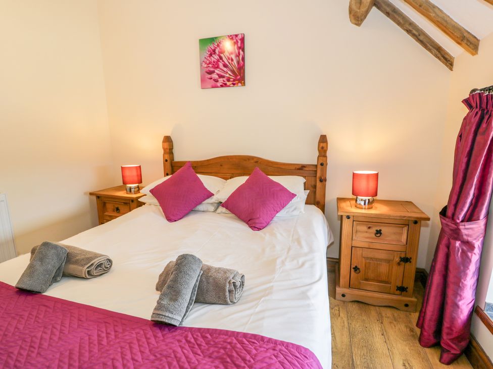 A bedroom with a bed and bedside tables at Beudy Bach, Dolwen near Abergele