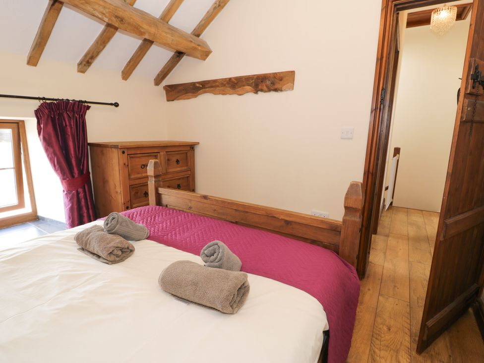 A bedroom with a bed and dresser at Beudy Bach in Dolwen near Abergele