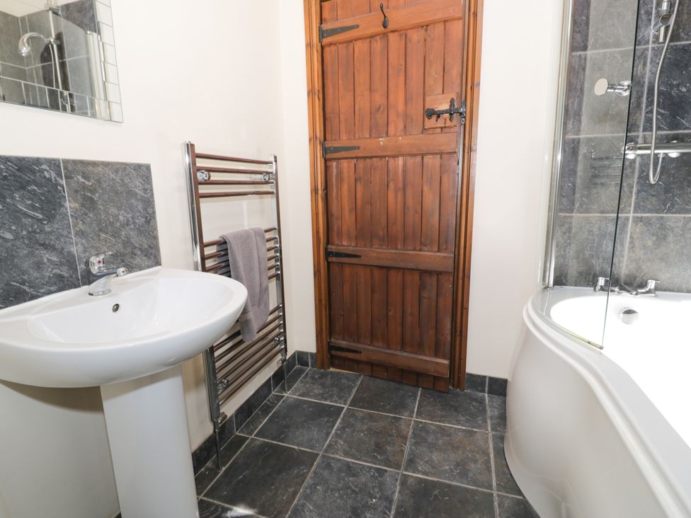 A bathroom with a wash basin and bathtub at Beudy Bach Dolwen near Abergele