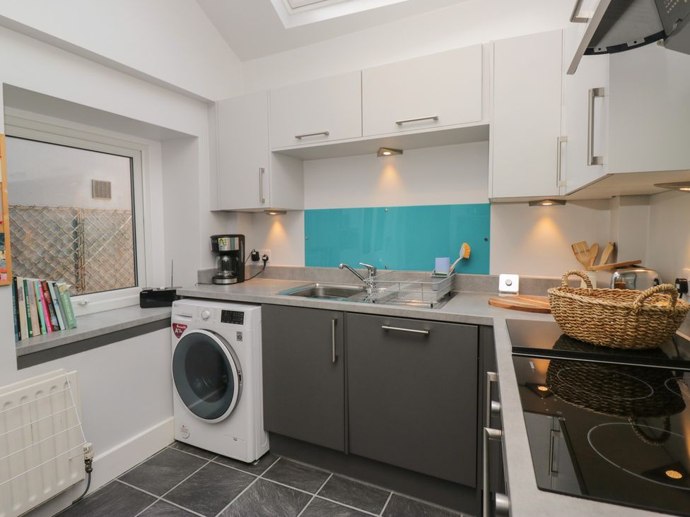 A kitchen with a washing machine and coffee maker at Number Thirty-Nine in Ulverston