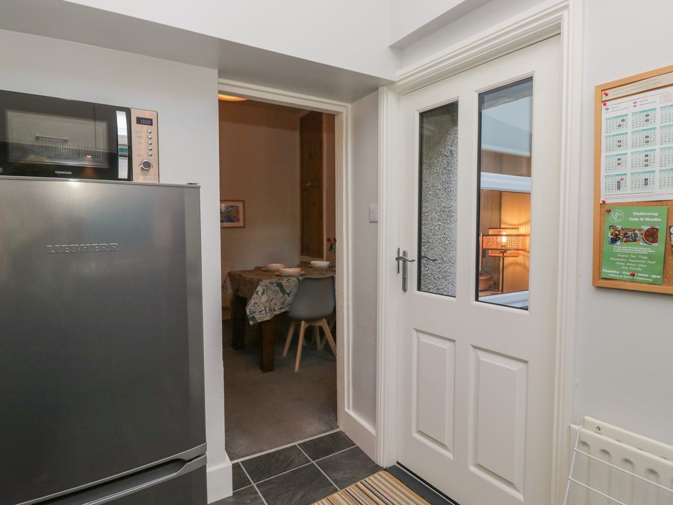 A kitchen with a refrigerator and a door leading to another room at Number Thirty-Nine, Ulverston