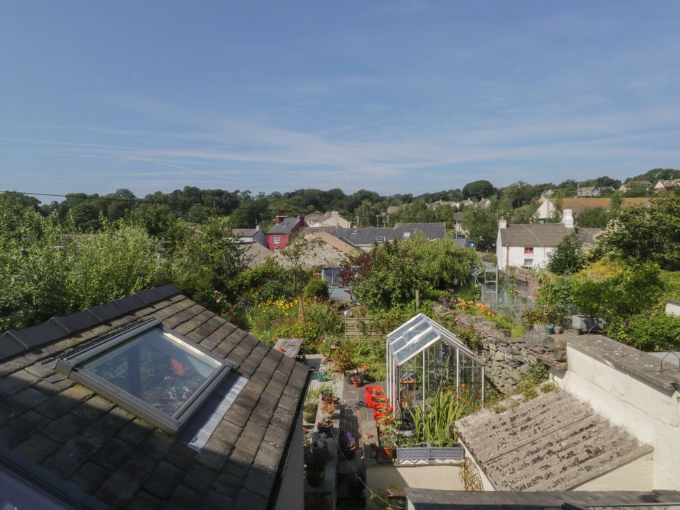 A view of a garden with a greenhouse and rooftops at Number Thirty-Nine in Ulverston