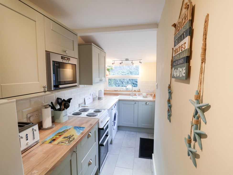 A kitchen with sink and appliances at Cobbler's Cottage in Mundesley