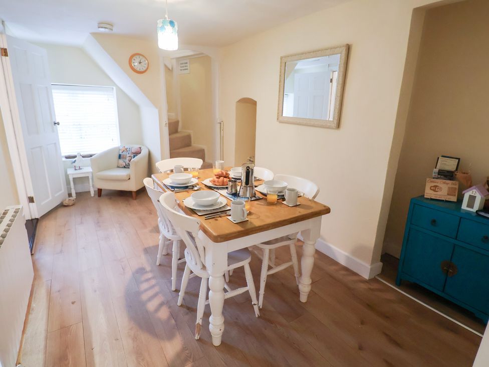 A dining room with a table set for breakfast at Cobbler's Cottage in Mundesley