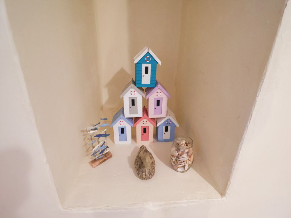 A display of decorative houses and shells in a niche at Cobbler's Cottage Mundesley