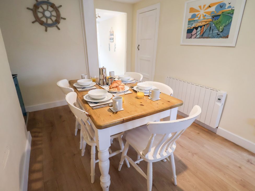 A dining room with a table set for breakfast at Cobbler's Cottage Mundesley