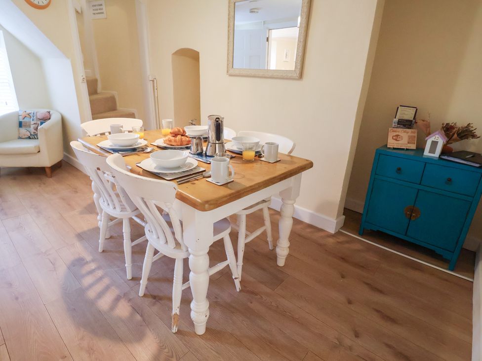 A dining room with a table set for breakfast at Cobbler's Cottage in Mundesley