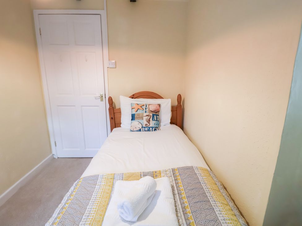 A single bed with a pillow and towel in a bedroom at Cobbler's Cottage in Mundesley