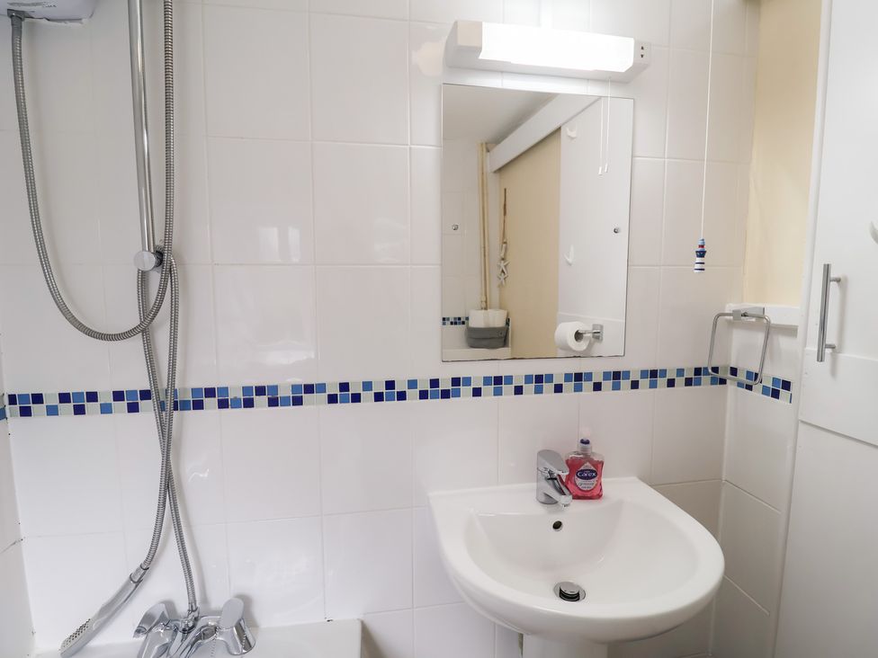 A bathroom with a sink and shower at Cobbler's Cottage in Mundesley