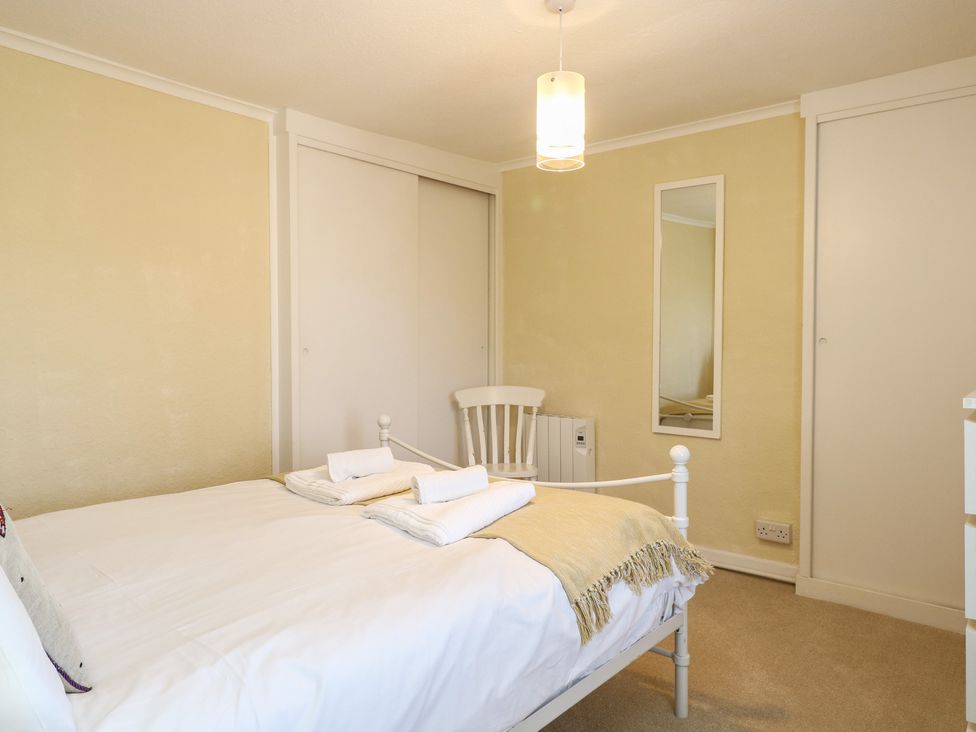 A bedroom with a bed and chair at Cobbler's Cottage in Mundesley