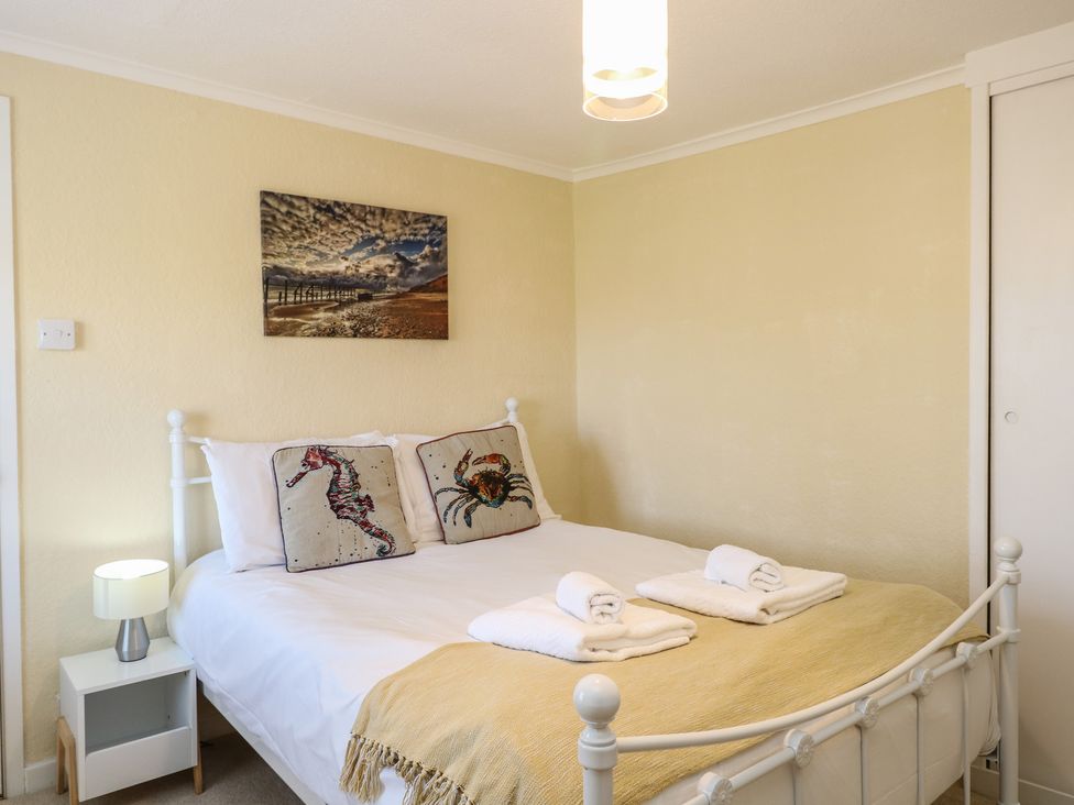 A bedroom with a bed and decorative pillows at Cobbler's Cottage in Mundesley
