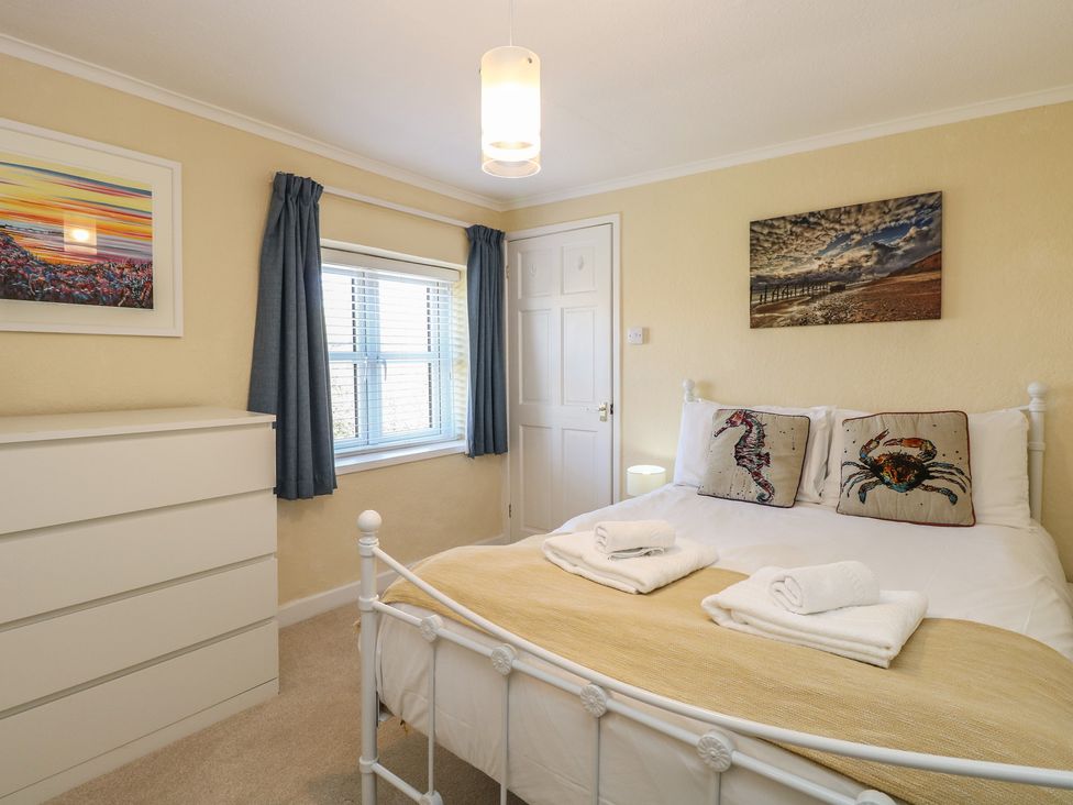 A bedroom with a bed and dresser at Cobbler's Cottage in Mundesley
