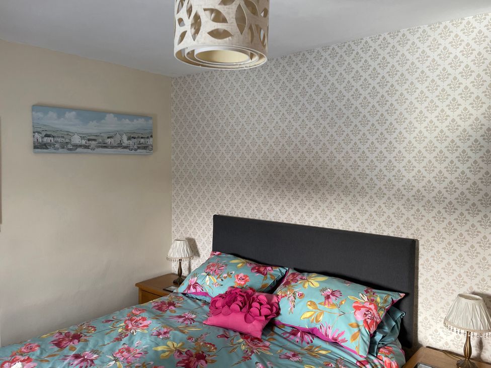 A bedroom featuring a bed with floral bedding at Willow Nook in Glaisdale near Lealholm