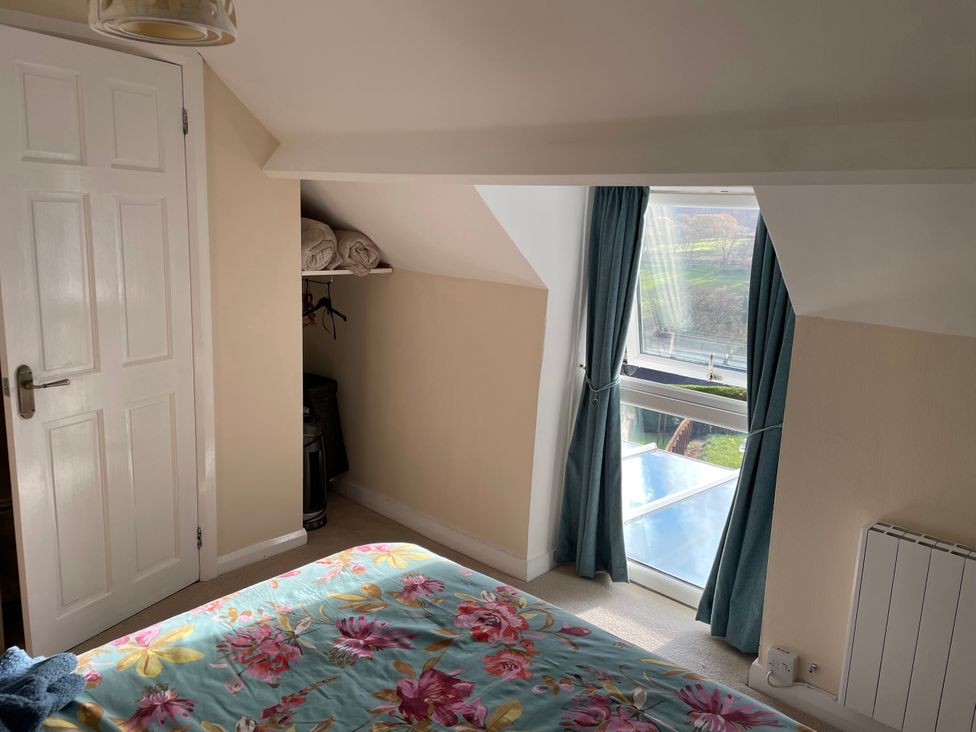 A bedroom with a window and blankets on a shelf at Willow Nook in Glaisdale near Lealholm