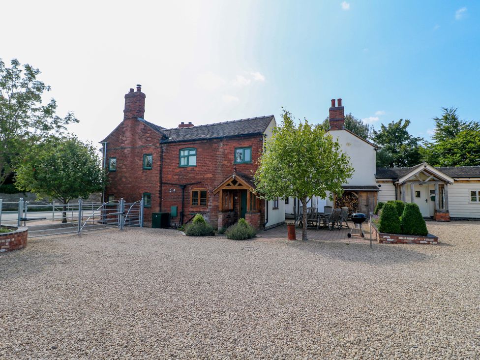 A house with trees and outdoor furniture at Bellamour End Cottage Rugeley