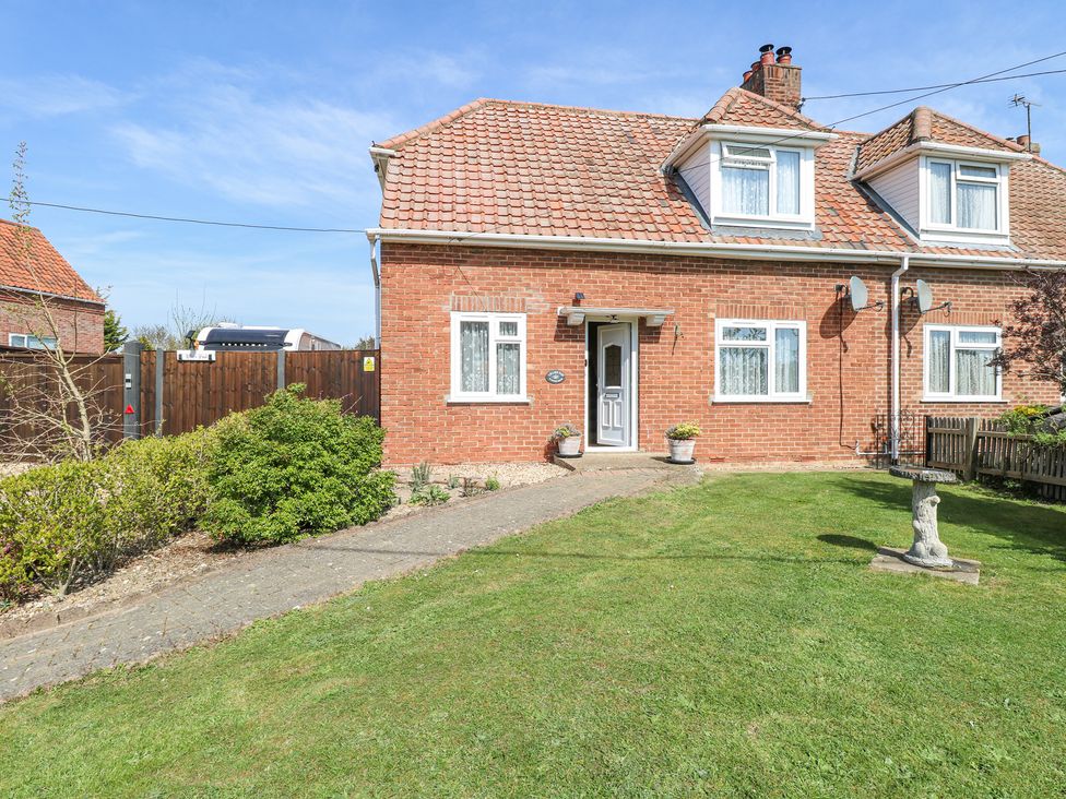 A brick house with a tiled roof and front garden with grass and bushes at Lillies Pad in Methwold near Feltwell
