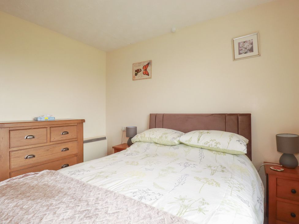 A bedroom with a bed and dresser at Underlanes in Boscastle