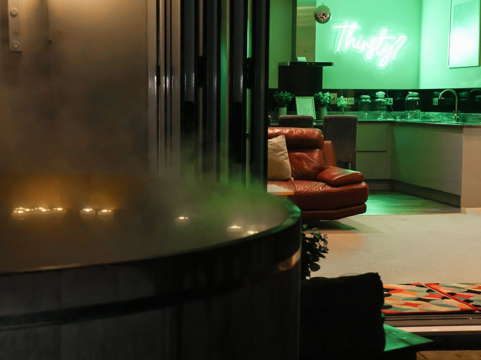 A living area with a hot tub and kitchen at Milton Manor in Milton On Stour