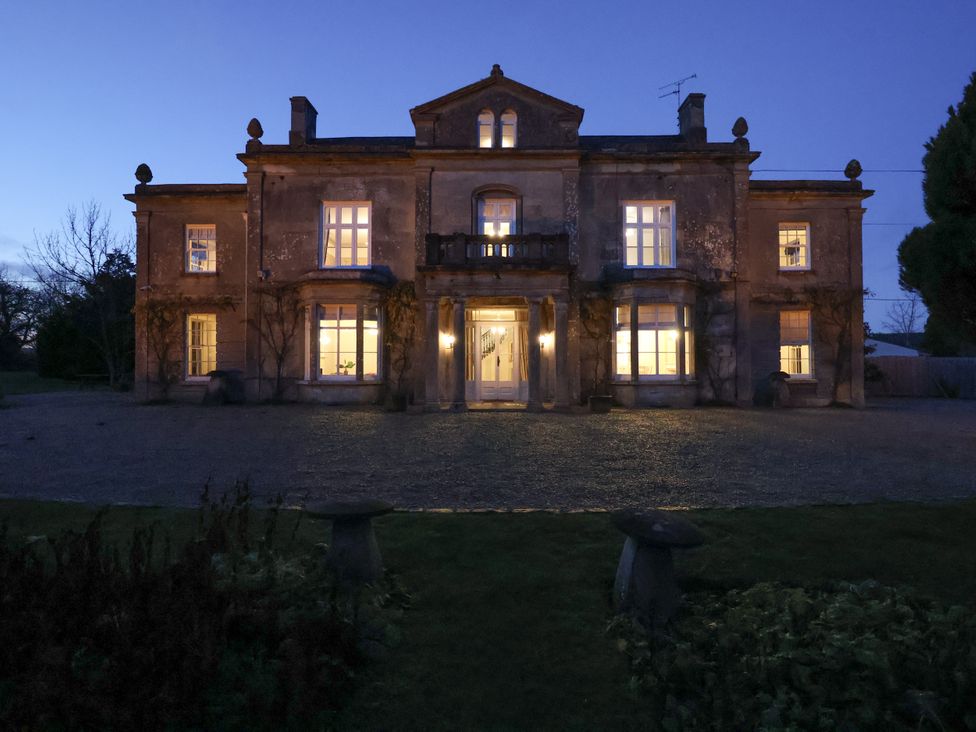 A large house with lights on at Milton Manor in Milton On Stour