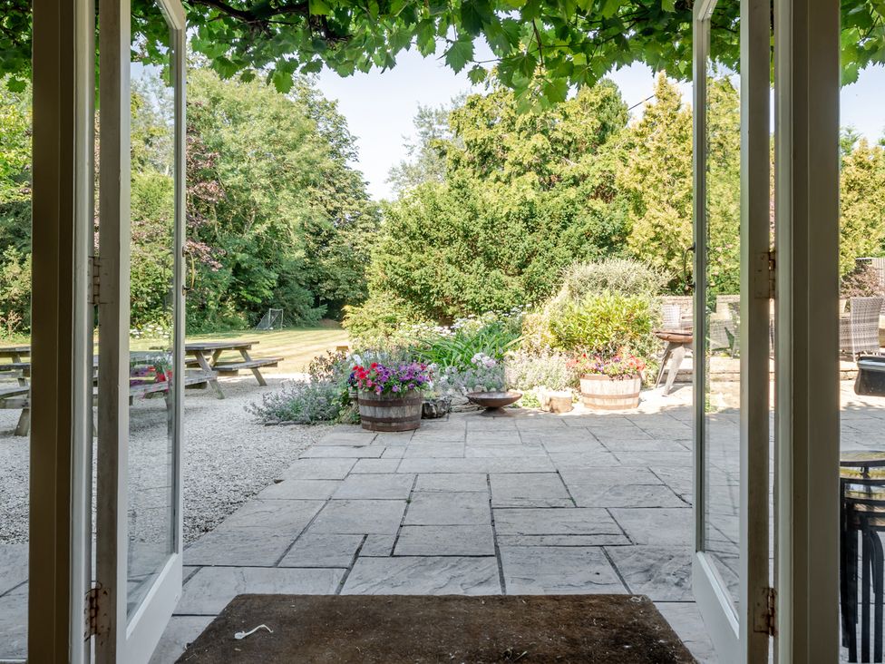 A garden with flower pots and picnic table at Milton Manor in Milton On Stour