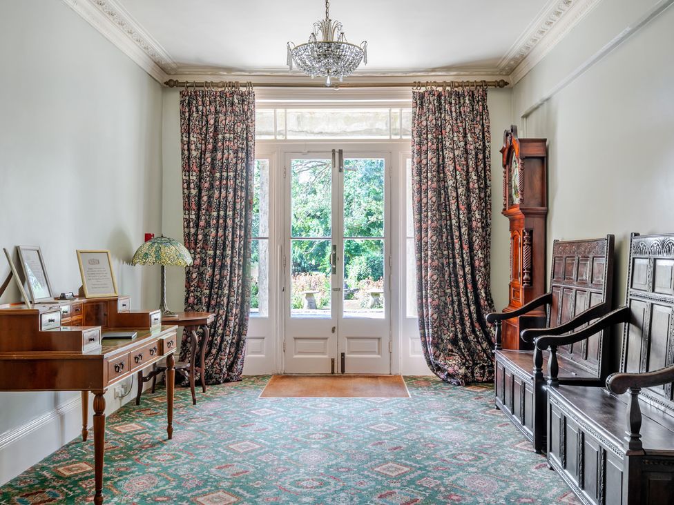 A hall with a table and decorative chairs at Milton Manor in Milton On Stour