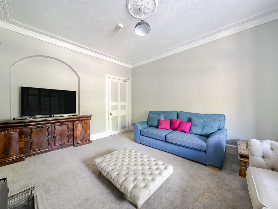 A living room with a sofa and a television at Milton Manor in Milton On Stour
