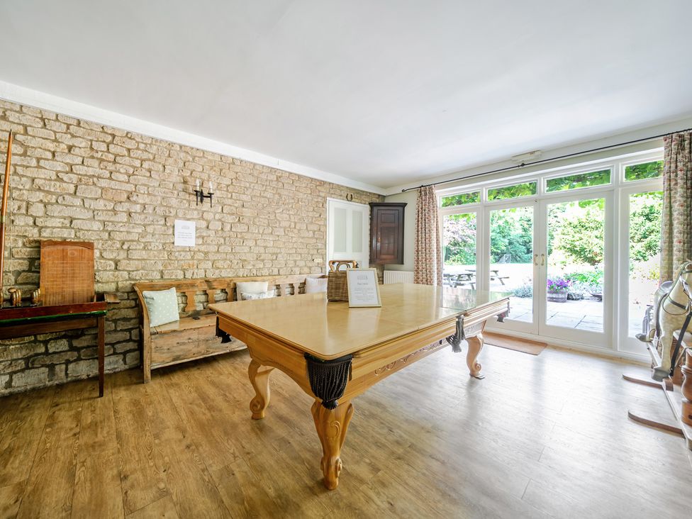 A dining room with a large table and benches at Milton Manor in Milton On Stour