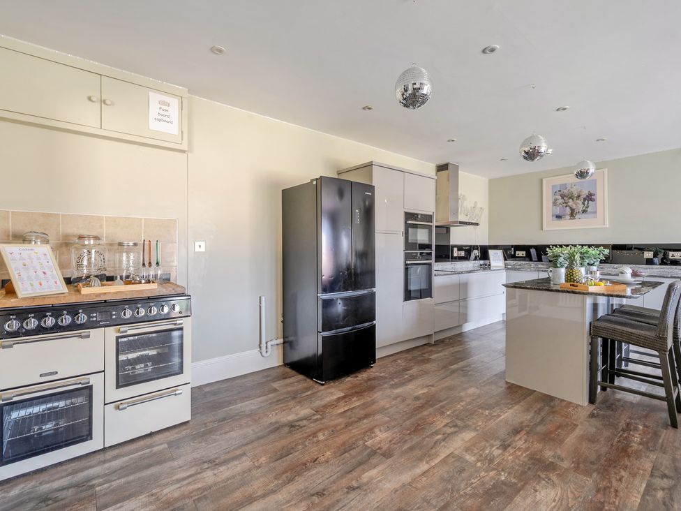 A kitchen with appliances and seating at Milton Manor in Milton On Stour