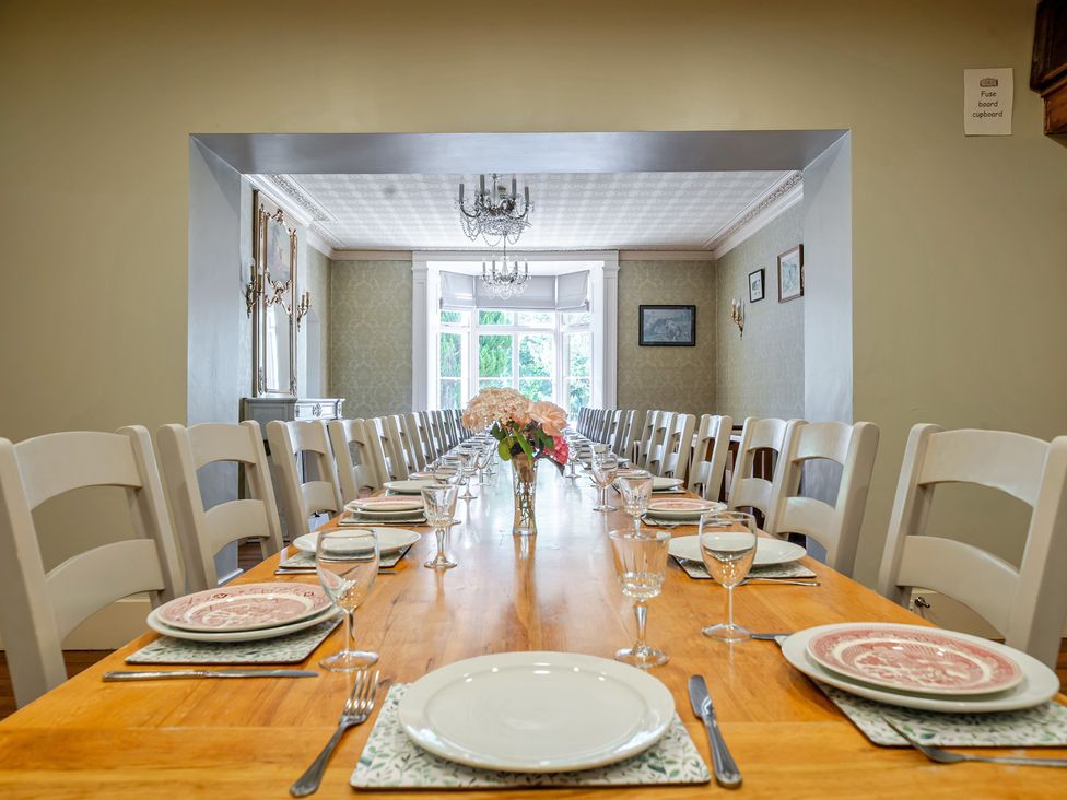 A dining room with a long table set for a meal at Milton Manor in Milton On Stour