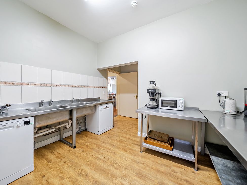 A kitchen with a sink, dishwasher, and countertop at Milton Manor in Milton On Stour