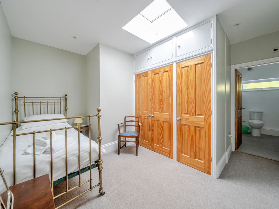 A bedroom with a bed and chair at Milton Manor in Milton On Stour