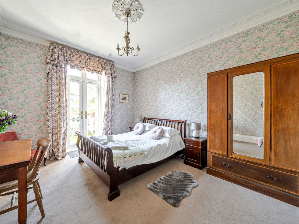 A bedroom with a bed and wardrobe at Milton Manor in Milton On Stour