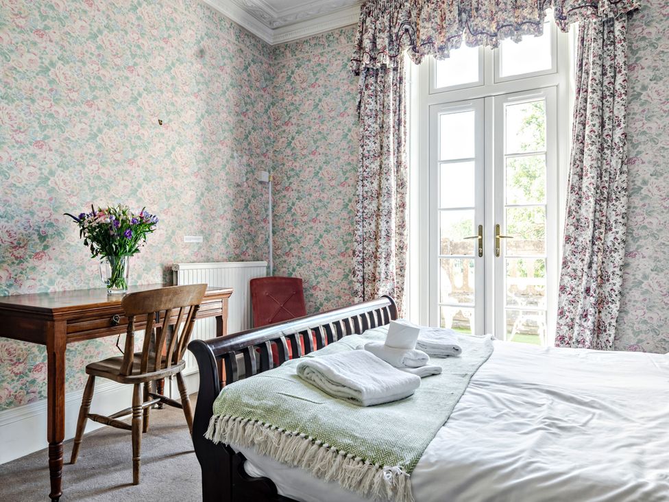 A bedroom with a bed and table at Milton Manor in Milton On Stour