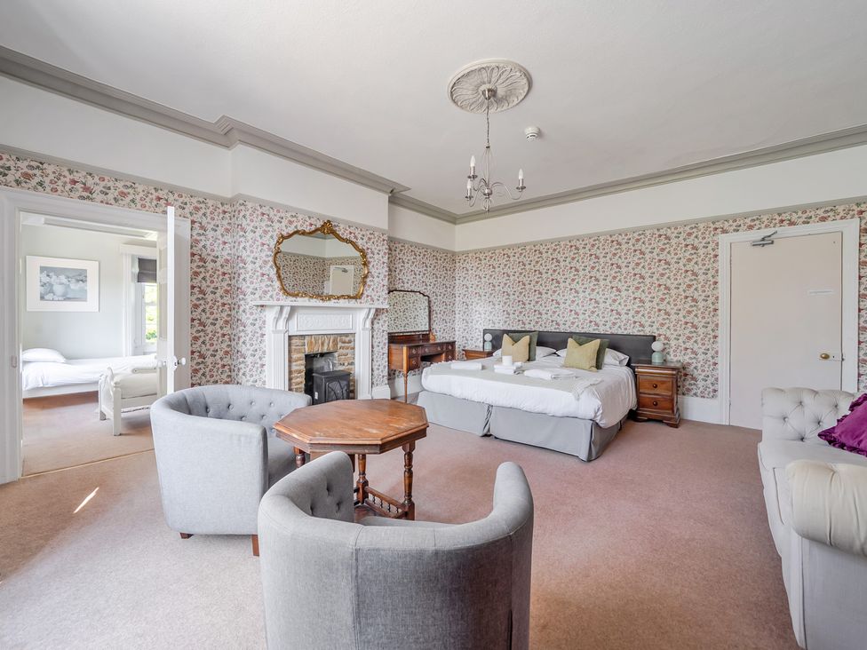 A bedroom with beds and a table at Milton Manor in Milton On Stour