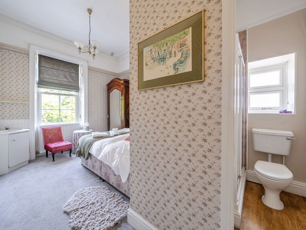 A bedroom with a bed and chair at Milton Manor in Milton On Stour