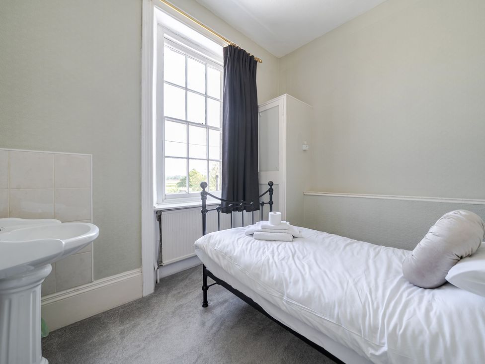 A bedroom with a bed and sink at Milton Manor in Milton On Stour