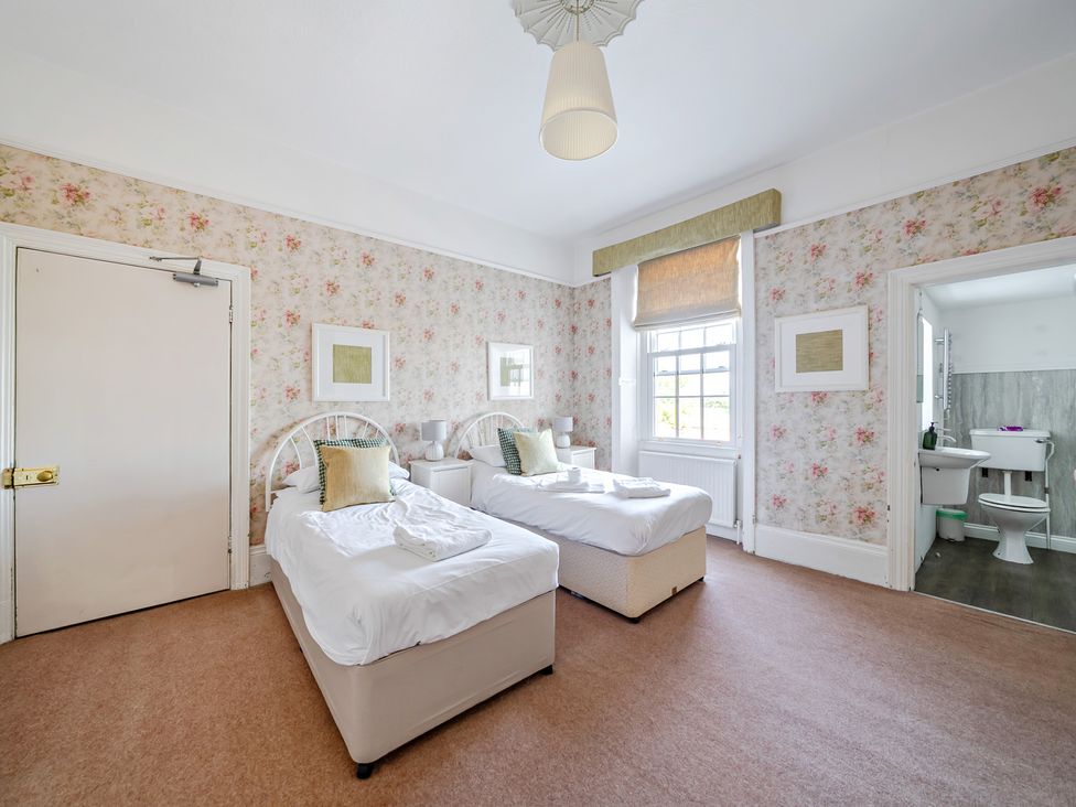 A bedroom with two beds and an adjoining bathroom at Milton Manor in Milton On Stour