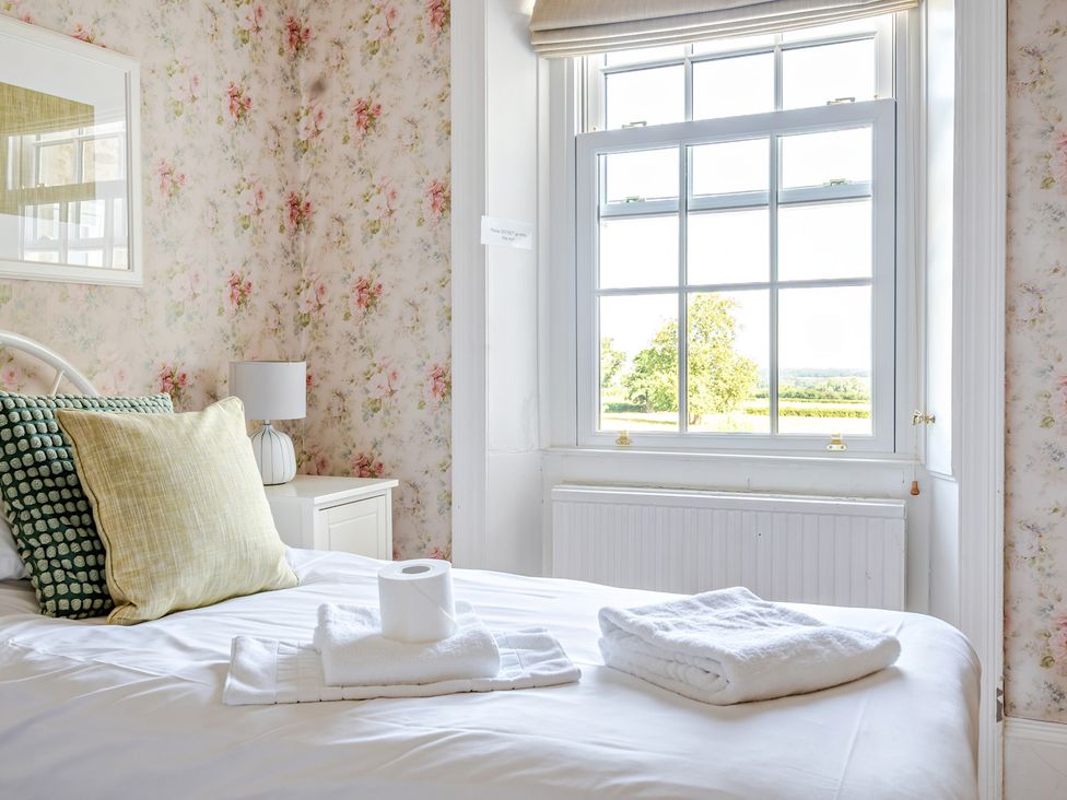 A bedroom with a bed and window at Milton Manor in Milton On Stour