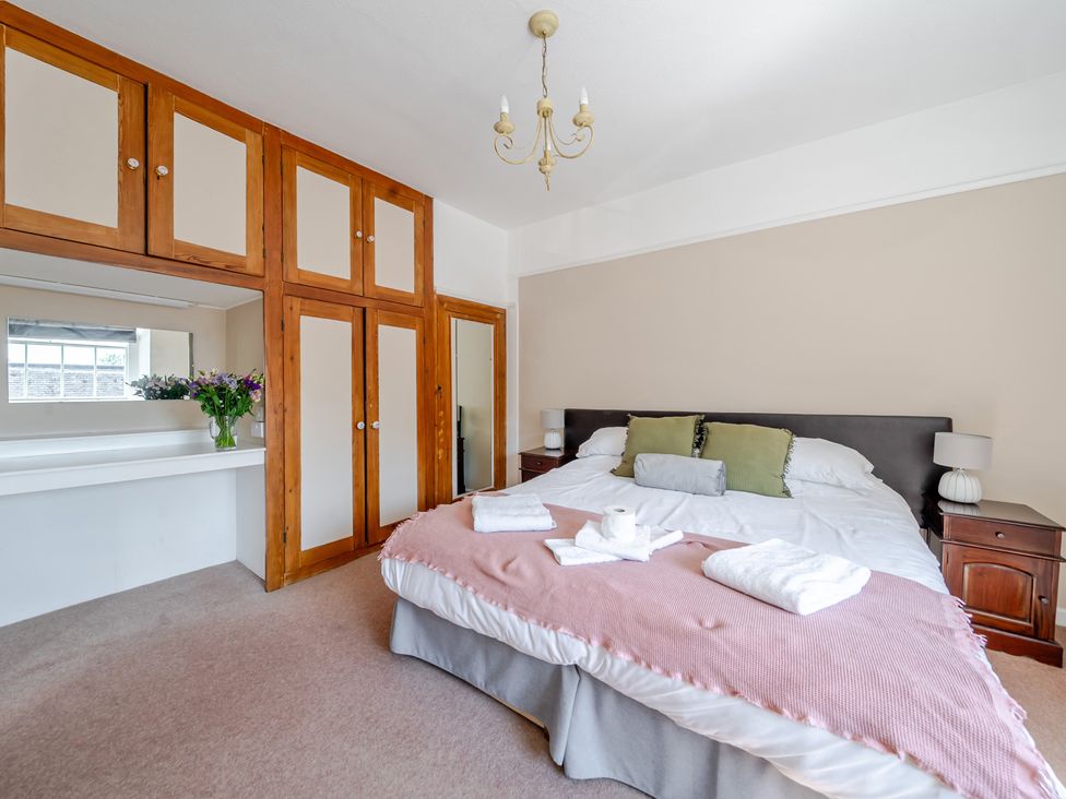 A bedroom with a bed and a mirror at Milton Manor in Milton On Stour